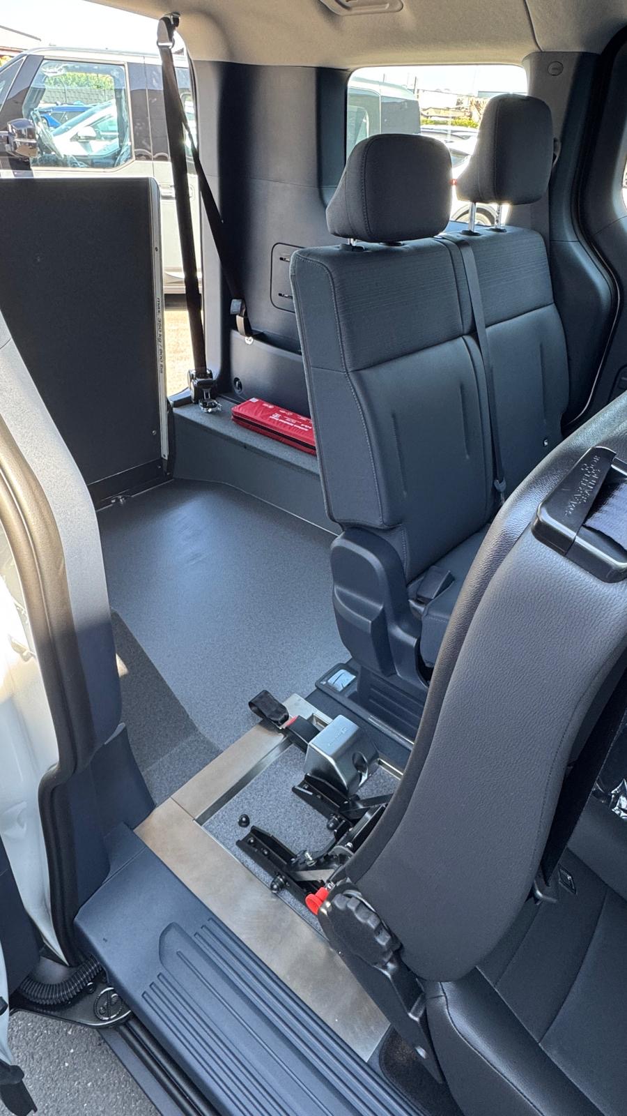 Innenraum eines umgebauten Kia PV5 mit Rollstuhlstellplatz